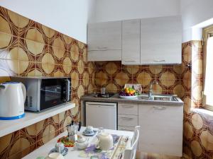 una pequeña cocina con mesa y microondas en Holiday Home Il Piccolo Nocelleto by Interhome, en SantʼAgata sui Due Golfi