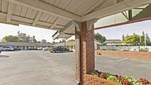 a building with a parking lot with a car lot at Americas Best Value Inn - Livermore in Livermore