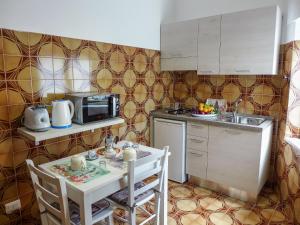 una pequeña cocina con mesa y microondas en Holiday Home Il Piccolo Nocelleto by Interhome, en SantʼAgata sui Due Golfi
