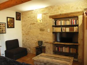 sala de estar con TV y silla en Domaine Saint Martin, en Valliguières