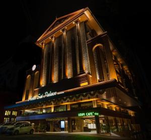 een gebouw waar een auto voor geparkeerd staat bij Hotel Sai Palace , Mangalore in Mangalore