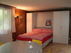 a small bedroom with a bed and a table at Apartment Sörenweg 5 by Interhome in Engelberg