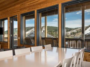 a table and chairs in a room with windows at Holiday Home Ameno 3 by Interhome in Jämsä