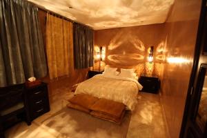 a bedroom with a large bed and a wooden wall at Riad Dar Haven in Tamraght Ou Fella