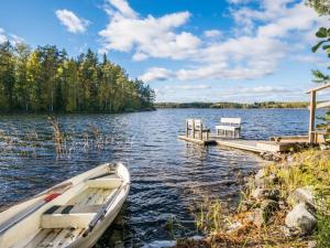 a boat on a lake with a dock at Holiday Home Kannonniemi by Interhome in Majavesi