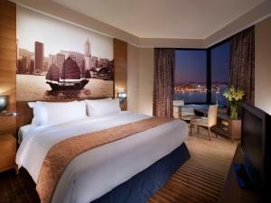 um quarto de hotel com uma cama grande e uma janela grande em Harbour Grand Hong Kong em Hong Kong