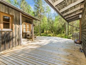 um deque de madeira ao lado de uma cabana na floresta em Holiday Home Lauhanlinna by Interhome em Isojoki