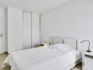 een witte slaapkamer met een wit bed en een lamp bij Apartment Roc Eden-1 by Interhome in Saint-Malo