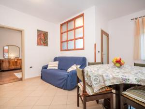 a living room with a blue couch and a table at Apartment Adriana by Interhome in Pješčana Uvala