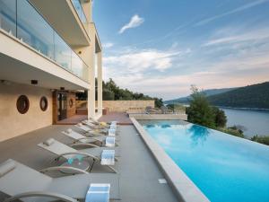 un hotel con piscina y tumbonas en Villa Vlastelini II by Interhome, en Hrvatini