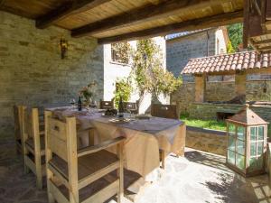 einen Tisch und Stühle auf einer Terrasse mit einem Tisch und einem Gebäude in der Unterkunft Holiday Home Il Giardino Dei Semplici by Interhome in Montanaldo