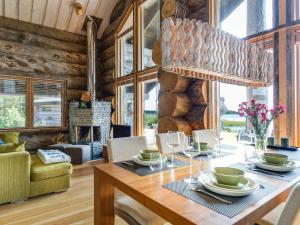 ein Esszimmer mit einem Holztisch und einem Kronleuchter in der Unterkunft Holiday Home Villa pärla by Interhome in Myllykangas
