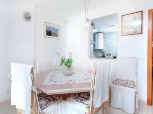 une salle à manger blanche avec une table et deux chaises dans l'établissement Apartment Marina Palace by Interhome, à Sant Antoni de Calonge