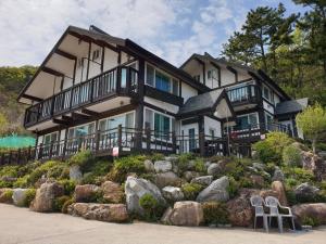a large house on top of a hill with rocks at Tongyeong Yehyang Pension in Tongyeong