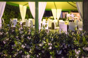 Zimmer mit weißen Stühlen und lila Blumen in der Unterkunft Hotel Marilù in Eraclea Mare