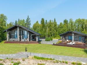 ein Blockhaus mit einem großen Garten und einer Terrasse in der Unterkunft Holiday Home Villa pärla by Interhome in Myllykangas