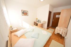 Habitación blanca pequeña con mesa y silla en Rooms Smilje - good location, en Orebić