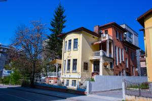 une maison jaune et blanche sur le côté d'une rue dans l'établissement Guest House Marrakech, à Gabrovo