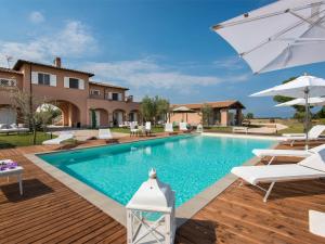 a swimming pool with chairs and an umbrella at Villa Marina Velca by Interhome in Tarquinia