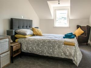 een slaapkamer met een bed en een raam bij Holiday Home Taobh na Mara by Interhome in Kensaleyre