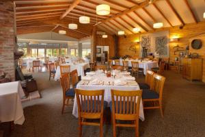 a dining room with white tables and wooden chairs at Glen Erin at Lancefield in Rochford