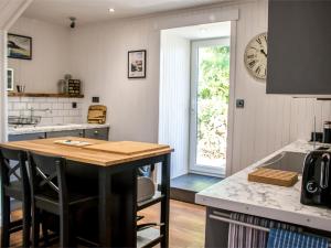 een keuken met een tafel en een klok aan de muur bij Holiday Home Taobh na Mara by Interhome in Kensaleyre