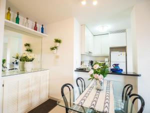 a dining room and kitchen with a glass table and chairs at Apartment Vista al Mar by Interhome in Port d'Alcudia +15 photos