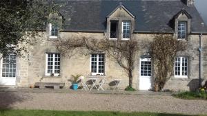 an old stone house with two chairs in front of it at LA LAMBERTERIE : LA BOULANGERIE in Yvetot Bocage