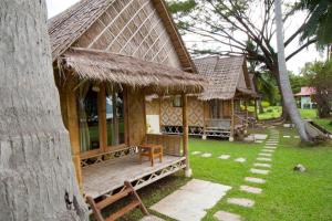 a house with a porch with a grass roof at SiBoya Bungalows in Siboya