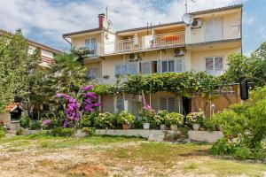 an apartment building with flowers in front of it at Apartment Nediljka in Vodice