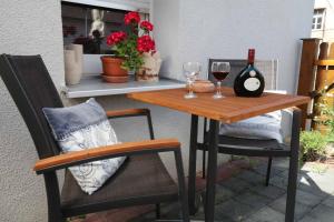 a table and two chairs with wine glasses on a patio at Ferienwohnung Altes Rathaus in Tauberbischofsheim