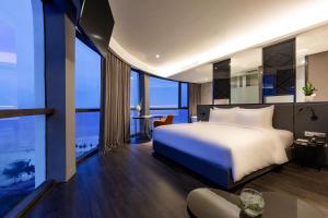 a hotel room with a bed and a couch at Stella Maris Beach Danang in Da Nang