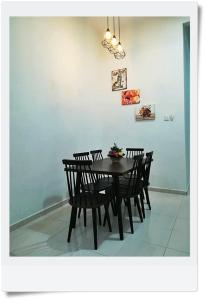 a dining room with a table with chairs and a wall at Fazz Homestay Melaka in Melaka