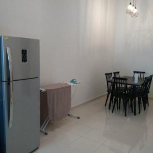 a kitchen with a table and a stainless steel refrigerator at Fazz Homestay Melaka in Melaka
