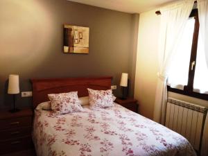 a bedroom with a bed with two pillows and a window at Apartamento Morlans Panticosa in Panticosa