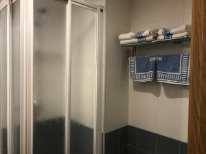 a shower in a bathroom with blue and white towels at Apartamento Morlans Panticosa in Panticosa