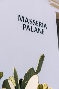 a cactus with a sign that reads massageena palanca at Masseria Palane in Pat&ugrave;