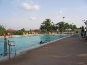 a large swimming pool with people in the water at Ca na Mora in Campanet