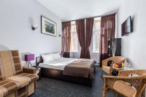 Habitación de hotel con cama y silla en Mini Hotel na Nevskom 136, en San Petersburgo