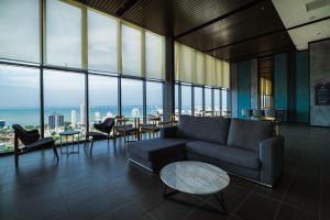 a living room with a couch and tables and windows at Muji Home 1 - Sea and City View 2BR at 218 Tropicana NEAR Komtar FoodHeaven with Netflix & TV Box in George Town