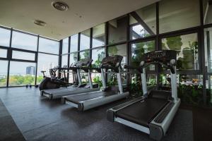 a row of treadmills in a gym with windows at Muji Home 1 - Sea and City View 2BR at 218 Tropicana NEAR Komtar FoodHeaven with Netflix & TV Box in George Town