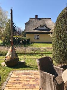 a brick patio with two chairs and a house at "Matrosenlogis" by Ferienhaus Strandgut in Born