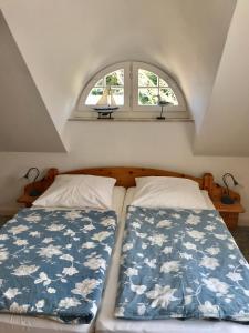 zwei Betten in einem kleinen Zimmer mit Fenster in der Unterkunft "Matrosenlogis" by Ferienhaus Strandgut in Born