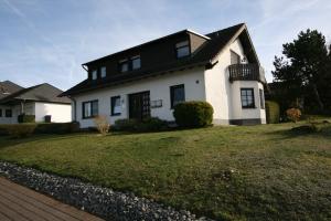 a white house with a black roof and a yard at Munterleyblick in Gerolstein