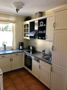 a kitchen with white cabinets and a sink at "Matrosenlogis" by Ferienhaus Strandgut in Born