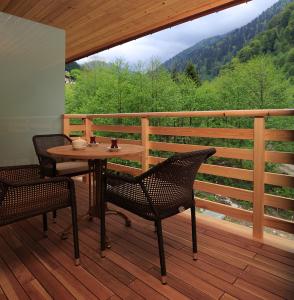 a wooden deck with a table and chairs on a balcony at Kackar Resort Hotel in Ayder Yaylasi