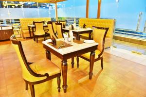 a dining room with tables and chairs in a restaurant at Citrus Classic Mcleodganj in Dharamshala