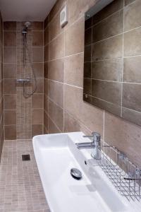 uma casa de banho com um lavatório branco e um chuveiro em Oak – Three Tuns Apartments em Pettistree