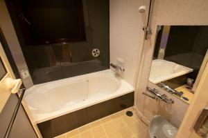 Baño pequeño con bañera y lavamanos en Hotel G-Style (Adult Only), en Tokio