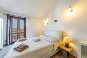 a white bedroom with a bed and a window at B&B Rotta Per Tavolara in Porto San Paolo